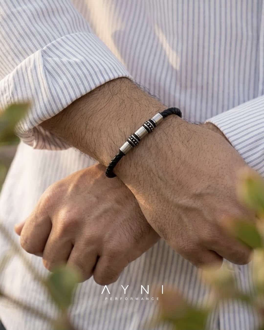 Pulsera AYNI de cuero trenzado y acero con dijes